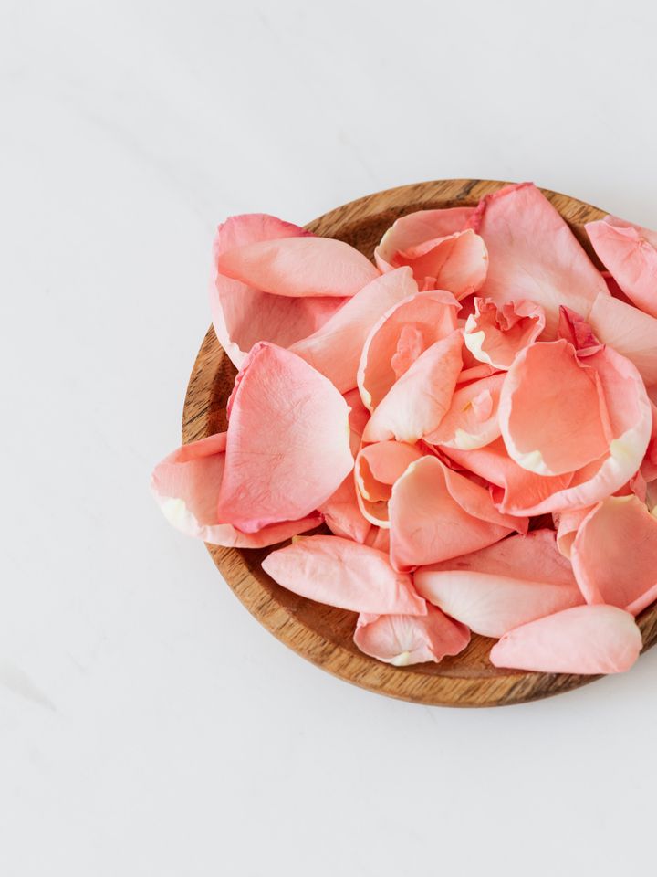 Sea Buckthorn — close-up of rich botanical rose petals in a wooden bowl, warm amber and rose tones, ingredient editorial
