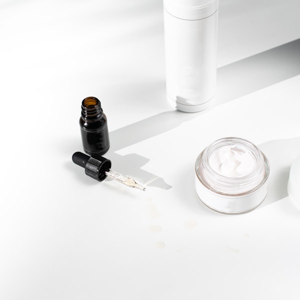Customer shelfie: three amber glass skincare bottles — pump, spray, and dropper — on a clean white textured surface